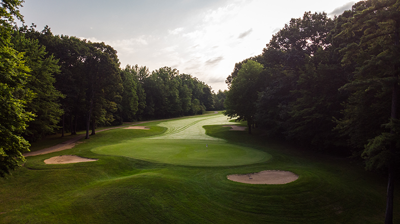 Aerial view of the course. A forest of trees blanket both sides.