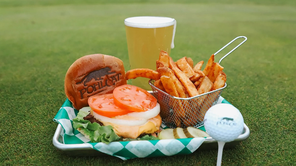 Plated burger, fry basket, and beer with golf ball on tee 